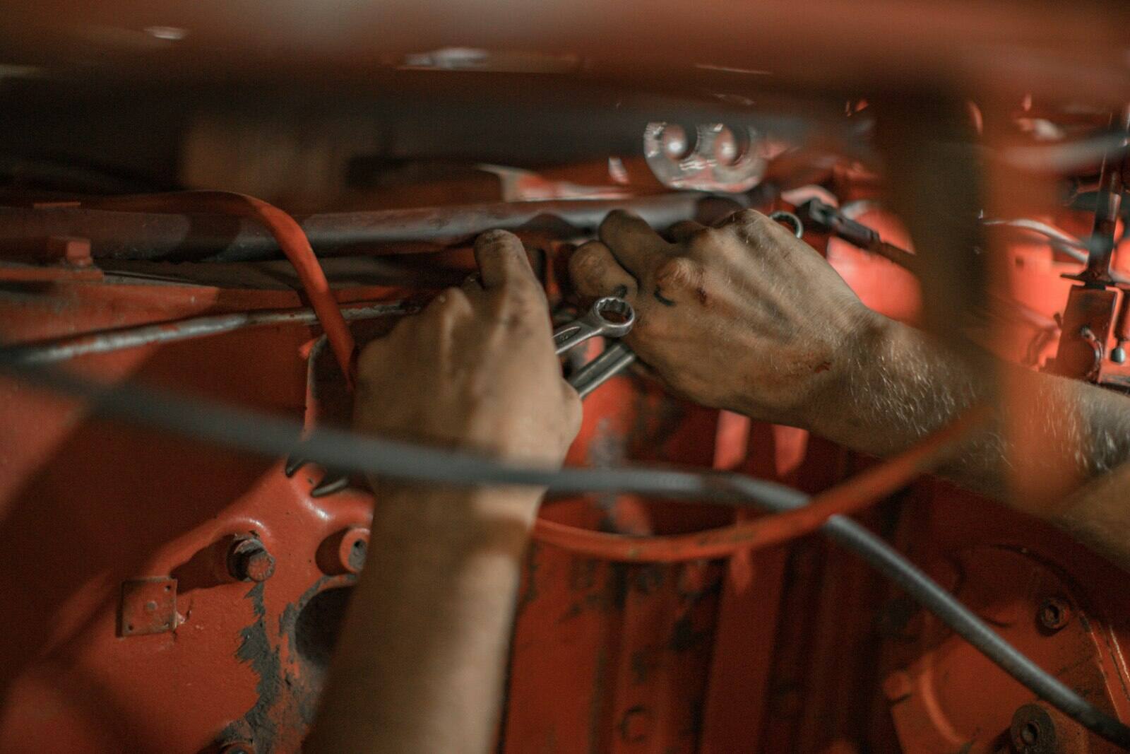 Hands repairing vehicle wiring and components