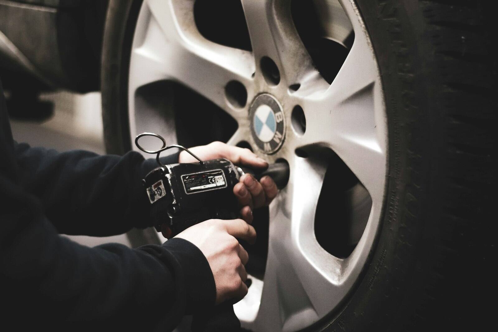 Wheel being removed with an impact wrench during tire service