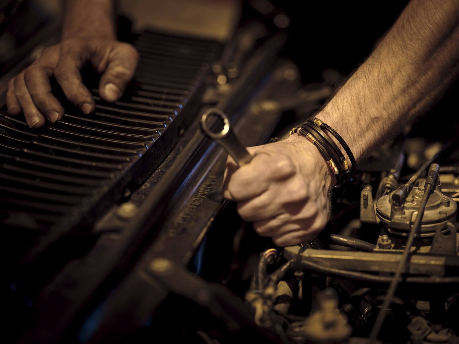 Mechanic tightening an engine component with a wrench
