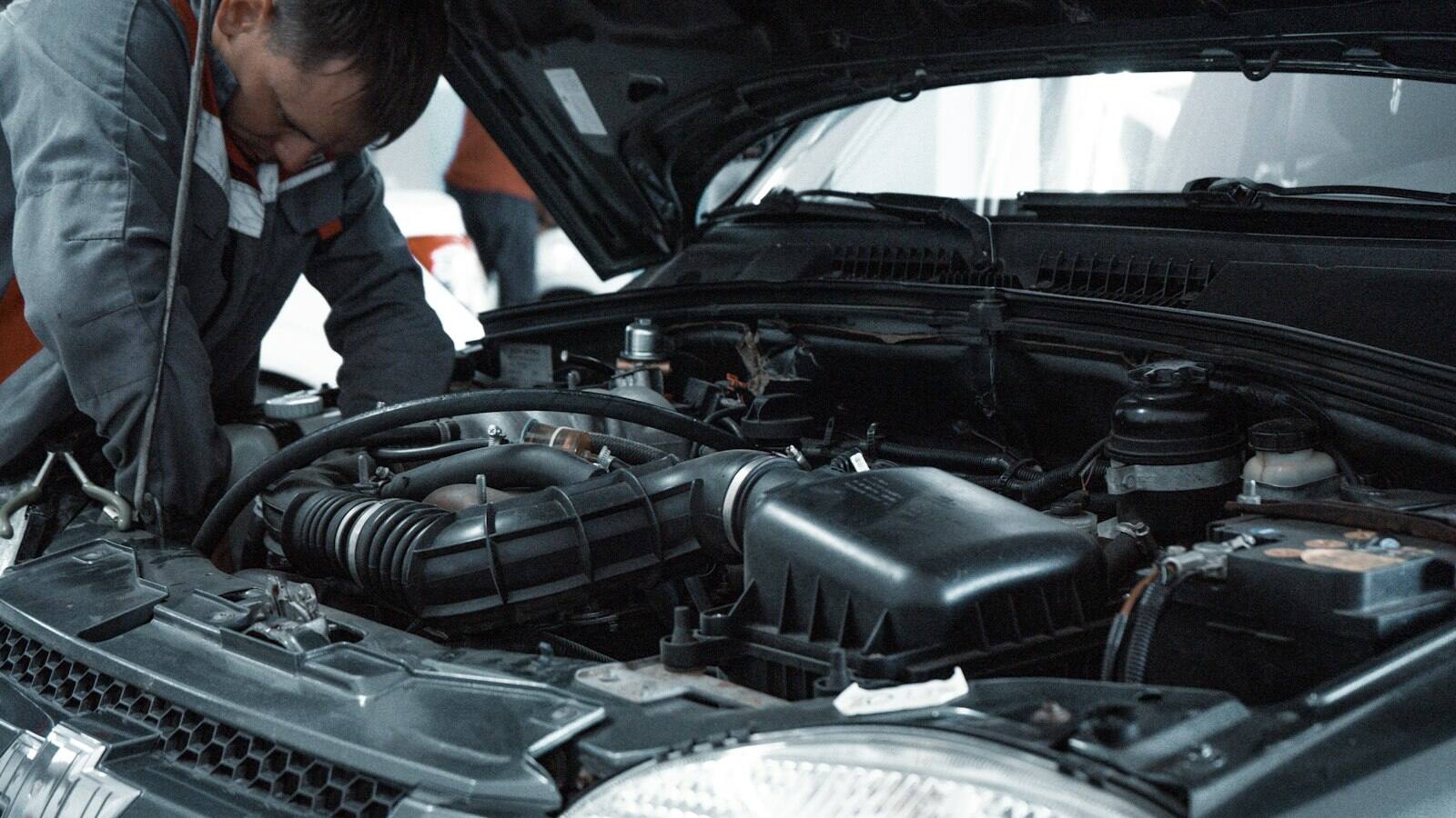 Technician inspecting a vehicle engine bay